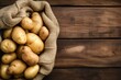 Raw potato food Fresh potatoes in an old sack on a wooden table, raw potatoes in a sack closeup, raw potatoes closeup, potatoes on a wooden table, potatoes closeup in the bag, a bag with potatoes
