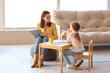 © Pixel-Shot - Female psychologist working with little girl at table in office