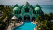 exterior view of the most beautiful and unique teal gothic mansion on a tropical island with an emerald green pool, the structure is symmetrical with lots of arches and ornate details