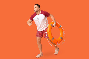 Wall Mural - Young lifeguard with lifebuoy running on orange background