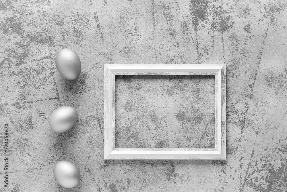 Beautiful composition with frame and Easter eggs on grey grunge background