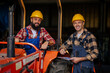 © Zamrznuti tonovi - Smiling colleagues making a plan of fixing tractor machine together.