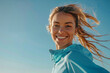 Portrait of smiling woman with jogs under blue sky. Female runner enjoying morning jogging