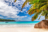 Fototapeta Miasta - Tropical Sunny beach with palm and turquoise sea on Seychelles. Summer vacation and tropical beach concept.	