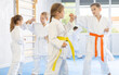 Young karate students engage in sparring match, demonstrating their martial art skills.