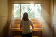 © Brian Powers - Young girl playing an old piano in front of a window