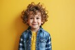 © Inigo - Portrait of a cute little boy with curly hair on a yellow background