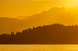 A setting sun casts a golden glow over the Olympic mountains and Puget Sound