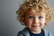 Portrait of a cute little boy with blond curly hair and blue eyes