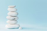 Fototapeta Desenie - Photo of A stack of white rocks on light blue background symbolizing balance and tranquility for selfcare product advertising