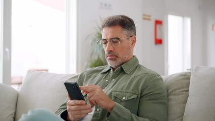 Wall Mural - Middle aged old man using smartphone relaxing on couch at home. Happy senior mature male user holding cellphone browsing internet, texting messages on mobile cell phone technology sitting on sofa.