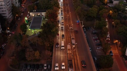 Wall Mural - Twilight traffic flows on a bustling city street with tram lines in Bucharest, aerial view