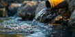 © tashechka - Water flows from a yellow pipe into a rocky area, creating a stream of dirty water