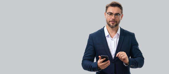 Wall Mural - Man using mobile phone isolated over studio background. Man in suit using smart phone cellphone for calls, social media, mobile app. Guy talking on the phone. Banner for header, copy space.