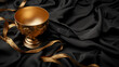 a golden cup of coffee is on a shiny satin cloth