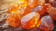 Translucent carnelian stones glow radiantly as sunlight filters through, atop a wooden surface