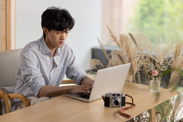 Young man using laptop in caf��