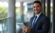 © Ilham - happy young latin business man executive holding tablet