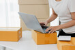 © Witoon - Startup small business entrepreneur or freelance Asian woman using a laptop with box, Young success Asian woman with her hand lift up, online marketing packaging box and delivery, SME concept.