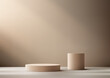 © rarinlada - 3D two beige cylinders on a light-colored floor with a shadowed wall behind them background with light beam