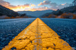 Photo of empty asphalt road with yellow dividing strip in the middle against sunset background. View from the yellow stripe