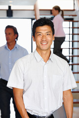 Wall Mural - Portrait, man and happy in creative team, worker in office workplace. Smile, professional and Asian male person in business, confident with staff for collaboration in company together in workspace