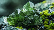 Deep green crystal formations with a translucent quality set against a contrasting rock base and mossy details