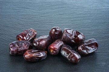 Wall Mural - Fresh Medjool Dates on black background. Healthy organic product.