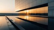© Artsaba Family - Reflective glass facade of a modern building capturing the golden hues of the sunset.