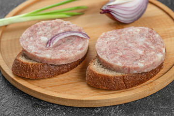 Wall Mural - Headcheese sandwich with onions on a wooden board