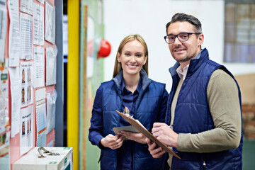 Wall Mural - Warehouse, clipboard and portrait of business people with smile for collaboration, compliance and inspection. Billboard, woman and man with checklist for report, teamwork and factory information