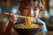 Child uses chopsticks to eat ramen noodles