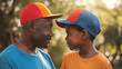African American Father and son with matching baseball caps looking at each other. Happy Father's day