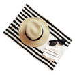 A sun hat and sunglasses lying on a beach towel, capturing the essence of summer relaxation, isolated on transparent background.