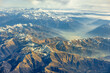 Aerial high altitude view of high peak mountains, Alps, in Switzerland's, Austria, France, Europe with snow cap on slope and warm morning light and clouds