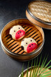 Cow-shaped bao buns in a traditional bamboo steamer; a whimsical twist on a classic Asian snack