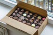 cardboard box with assorted chocolates near kitchen window