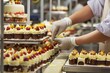 person manually decorating cakes on factory assembly line