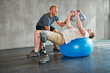 © peopleimages.com - Amputee, physiotherapist and help with kettlebells or exercise ball at gym for recovery, strength and healthcare rehabilitation. Physiotherapy, coach and support or consultation or workout for man
