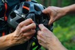 © altitudevisual - closeup of hands adjusting helmet strap before hike