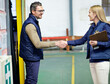© peopleimages.com - Business people, shaking hands and welcome for partnership, collaboration and agreement. Professional, clipboard and handshake for introduction, b2b onboarding or teamwork in shipping warehouse