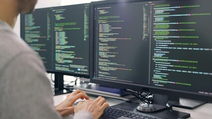 A focused individual program using an advanced multi-monitor computer setup, indicative of a professional software development environment.