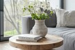 Simple decoration in a light living room. A vase with flowers on a small wooden table. Modern interior.