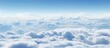 A panoramic view of a cloudy sky from an airplane, showcasing cumulus clouds and the horizon against the natural landscape