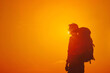 Adventurous traveler with a backpack, isolated on a vibrant sunset orange background, symbolizing exploration and wanderlust 