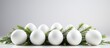 A row of white eggs with green leaves displayed on a table, a perfect natural ingredient for a dish or an event decor. The contrast of colors creates a fashionable accessory inspired by nature