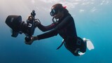 Fototapeta  - Female Indian underwater photographer swims with big underwater camera. Female freediver with camera swims in the sea