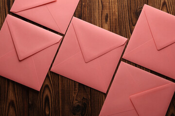 Wall Mural - Pink square paper envelopes on wooden background