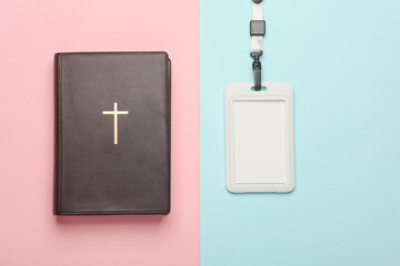 Wall Mural - Religious volunteering, messianism. Bible with cross and id card on string, pink blue background