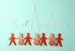People Chain with a cardiological heart rhythm cut out of paper on blue background. Nation health